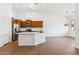 Open-concept kitchen features a large island, stainless steel appliances, wood cabinets, and an adjacent dining area at 8758 W Myrtle Ave, Glendale, AZ 85305