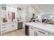 Bright open floorplan featuring kitchen with white cabinets, wine fridge, and view into the living room at 8965 E Maple Dr, Scottsdale, AZ 85255