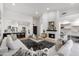Bright living room features a fireplace, light hardwood floors, and opens to a modern kitchen with stainless steel appliances at 8965 E Maple Dr, Scottsdale, AZ 85255