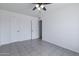 Bright bedroom boasts tile flooring, ceiling fan, and two closets at 929 W Knowles Cir, Mesa, AZ 85210