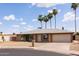 Inviting home featuring desert landscaping, tall palm trees, and a two-car attached garage at 929 W Knowles Cir, Mesa, AZ 85210