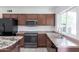 Well-lit kitchen features stainless appliances, granite countertops, and dark wood cabinetry at 929 W Knowles Cir, Mesa, AZ 85210
