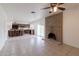 Spacious living room with tile flooring and a brick fireplace, connecting to an open-concept kitchen at 929 W Knowles Cir, Mesa, AZ 85210