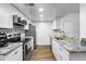 Modern kitchen with stainless steel appliances, granite countertops, and white cabinets at 1032 E Redfield Rd, Tempe, AZ 85283