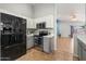 Updated kitchen boasts stainless appliances, gray and white cabinets, and a breakfast bar at 10646 E Enid Ave, Mesa, AZ 85208