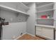 Spacious laundry room with tile floor, utility sink, storage cabinet, and open shelves at 10646 E Enid Ave, Mesa, AZ 85208
