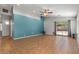 Open living room with bright accent wall, ceiling fan, and sliding glass doors to the backyard at 10646 E Enid Ave, Mesa, AZ 85208