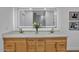 Bathroom featuring double sinks, wood cabinetry, a bright mirror, and modern fixtures at 10844 N 37Th Way, Phoenix, AZ 85028