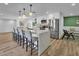 Open-concept kitchen featuring a large kitchen island with seating, stainless steel appliances and modern pendant lights at 10844 N 37Th Way, Phoenix, AZ 85028