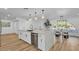 Modern kitchen featuring a large island with seating, white cabinets, stainless steel appliances and hardwood floors at 10844 N 37Th Way, Phoenix, AZ 85028