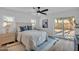 Serene main bedroom with a ceiling fan, plush bedding, and a sliding glass door to the backyard at 10844 N 37Th Way, Phoenix, AZ 85028