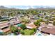 An aerial view capturing a neighborhood with swimming pools, mature trees, and a glimpse of the mountains at 11011 N 39Th St, Phoenix, AZ 85028