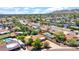 Aerial shot highlighting a neighborhood with mature trees, swimming pools, and mountain views in the distance at 11011 N 39Th St, Phoenix, AZ 85028