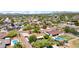 Expansive aerial view showcasing a neighborhood with lush greenery, swimming pools, and mountain views at 11011 N 39Th St, Phoenix, AZ 85028