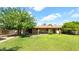 Large backyard featuring mature trees, a grassy lawn, and a covered patio for comfortable outdoor enjoyment at 11011 N 39Th St, Phoenix, AZ 85028