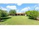 Spacious backyard with green grass, mature trees, and a covered patio, creating a perfect outdoor oasis at 11011 N 39Th St, Phoenix, AZ 85028