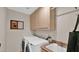 Bright laundry room features a washer, dryer, and sink with upper storage cabinets at 11011 N 39Th St, Phoenix, AZ 85028