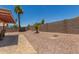 Low-maintenance backyard with desert landscaping and block fence at 1180 W Rosal Ave, Apache Junction, AZ 85120