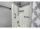 Bathroom shower with tiled walls, safety bar, shower head, and toiletry storage at 1180 W Rosal Ave, Apache Junction, AZ 85120
