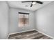Well-lit bedroom featuring a window, wood-look floors, ceiling fan and neutral colors at 1180 W Rosal Ave, Apache Junction, AZ 85120