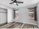 Bedroom featuring hard surface floors, ceiling fan, closet, and two windows allowing natural light at 1180 W Rosal Ave, Apache Junction, AZ 85120