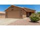 Beige single-story house with a large garage and a blossoming bush at 1180 W Rosal Ave, Apache Junction, AZ 85120