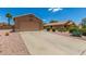 Single story home featuring desert landscaping, large driveway, and two-car garage at 1180 W Rosal Ave, Apache Junction, AZ 85120