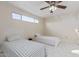 Bright bedroom features two twin beds, tile flooring, ceiling fan, and a window for natural light at 1235 E Dover St, Mesa, AZ 85203