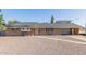 Charming single-story brick home featuring a low-maintenance gravel yard and covered carport at 1235 E Dover St, Mesa, AZ 85203