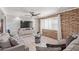 Comfortable living room with a brick wall, plank-style wall, and ceiling fan at 1235 E Dover St, Mesa, AZ 85203