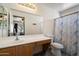 Bathroom with a large mirror, tile floors, sink and toilet with a blue and white shower curtain at 12410 W Flores Dr, El Mirage, AZ 85335