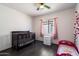 Cozy Bedroom with dark wood floors, a ceiling fan, a baby crib, and a toddler bed at 12410 W Flores Dr, El Mirage, AZ 85335
