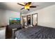 This bedroom includes a television with a ceiling fan, a dresser and a closet at 12410 W Flores Dr, El Mirage, AZ 85335