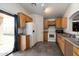 Bright kitchen with white appliances, wood cabinets, and sleek gray tile flooring, flowing natural light at 12410 W Flores Dr, El Mirage, AZ 85335