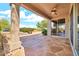 Covered back patio view with ceiling fan, stone flooring and a built-in grill at 15101 W Waterford Dr, Surprise, AZ 85374