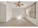Inviting bedroom with ceiling fan, neutral paint, large window and tile flooring at 15101 W Waterford Dr, Surprise, AZ 85374