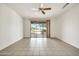 Spacious bedroom with tile flooring, ceiling fan, and sliding glass door to the patio at 15101 W Waterford Dr, Surprise, AZ 85374