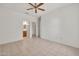 Bedroom featuring tile flooring, ceiling fan, and access to the bathroom and walk-in closet at 15101 W Waterford Dr, Surprise, AZ 85374