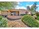Rear exterior view of home with landscaping including green bushes and gravel ground covering at 15101 W Waterford Dr, Surprise, AZ 85374