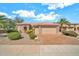 Charming home featuring a three-car garage, desert landscaping, and a red tile roof at 15101 W Waterford Dr, Surprise, AZ 85374