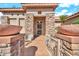 Inviting front entryway with stone accents and decorative planter pots at 15101 W Waterford Dr, Surprise, AZ 85374