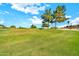 Golf course view of the community featuring green grass, mature trees, and blue skies at 15101 W Waterford Dr, Surprise, AZ 85374