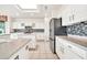 Modern kitchen with white cabinets, granite countertops, and stainless steel appliances at 15101 W Waterford Dr, Surprise, AZ 85374