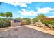 View of the backyard patio with built-in barbecue, outdoor kitchen and a rock water feature at 15101 W Waterford Dr, Surprise, AZ 85374