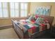 Cozy bedroom with wooden bed frame, colorful quilt, and bright natural light from the window at 15221 N Clubgate Dr # 2044, Scottsdale, AZ 85254