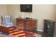 Bedroom with warm light, dresser with television, and striped armchair at 15221 N Clubgate Dr # 2044, Scottsdale, AZ 85254