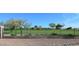 View of golf course and clubhouse beyond iron fence, set against a vibrant blue sky with scattered trees at 15221 N Clubgate Dr # 2044, Scottsdale, AZ 85254