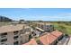 An aerial view showcasing the residential complex with its varied rooftops and surrounding area, including a golf course at 15802 N 71St St # 552, Scottsdale, AZ 85254