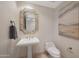 Elegant bathroom with a pedestal sink, uniquely decorated mirror, and a modern low-flow toilet at 15802 N 71St St # 552, Scottsdale, AZ 85254