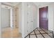A brightly lit hallway with decorative tile flooring and multiple doors, leading to different areas of the home at 15802 N 71St St # 552, Scottsdale, AZ 85254